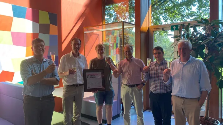 The CarbSorbTec team celebrating with champagne, holding the official CarbSorbTec B.V. UT spin-off certificate